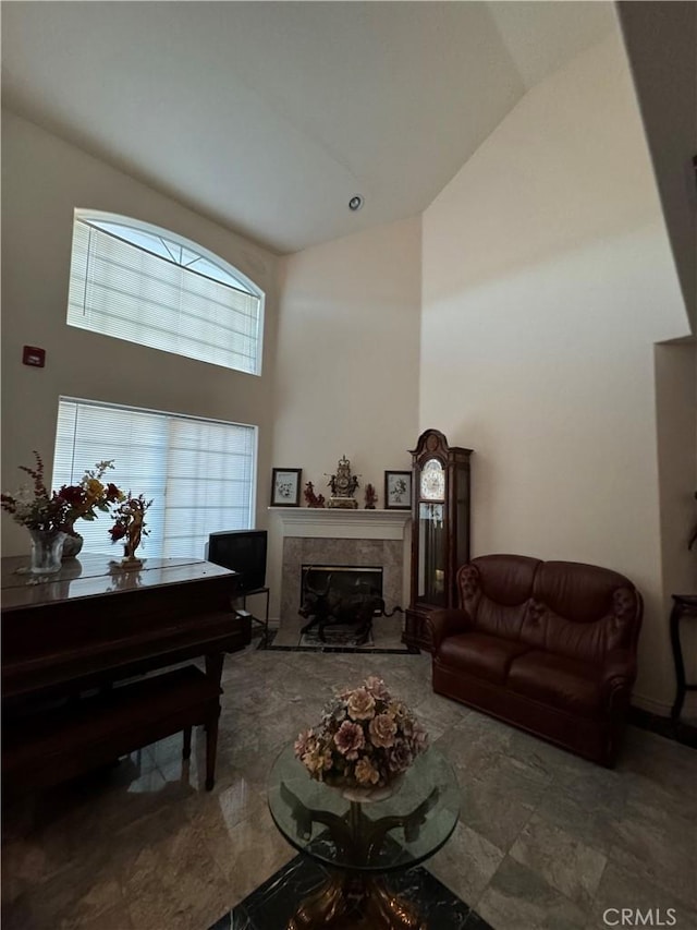 living room featuring a towering ceiling and a tiled fireplace