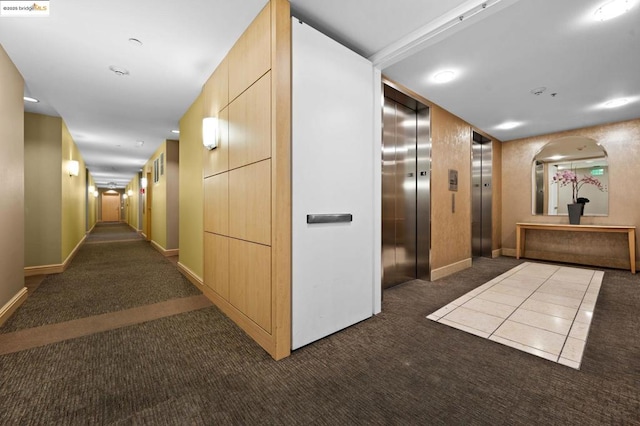 hall with elevator and dark carpet