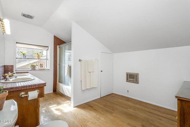 bathroom with enclosed tub / shower combo, vanity, lofted ceiling, and wood-type flooring