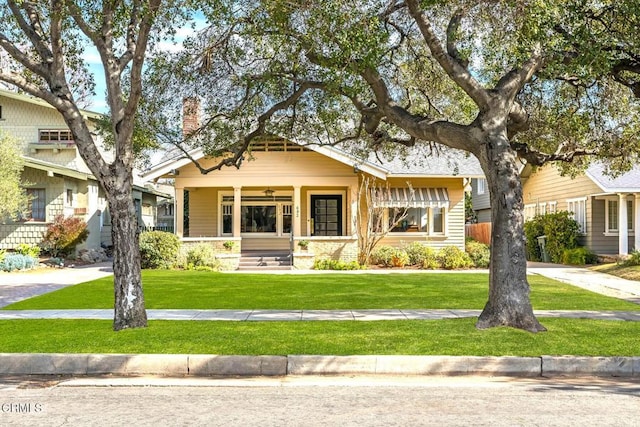 view of front of house with a front yard and covered porch