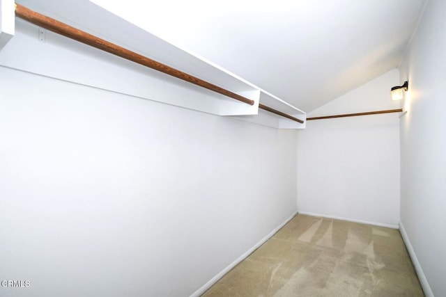 spacious closet featuring light colored carpet and vaulted ceiling