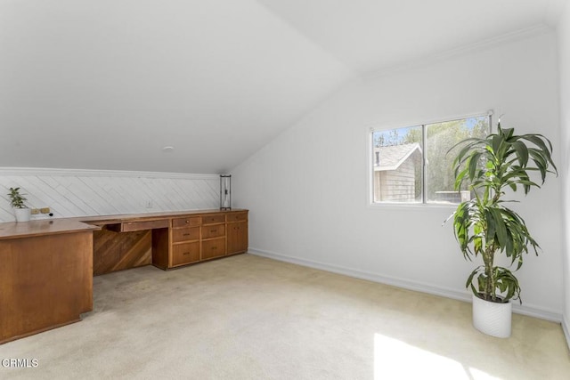 carpeted home office featuring built in desk and vaulted ceiling