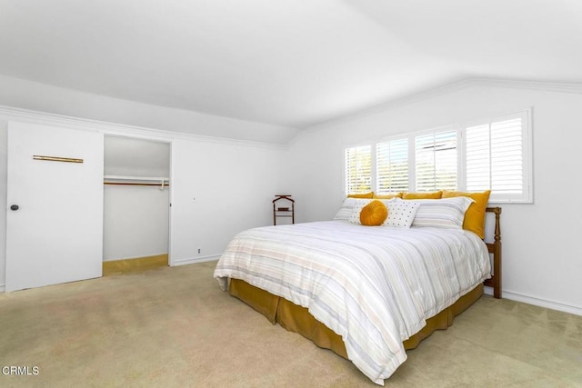 bedroom with vaulted ceiling, ornamental molding, light colored carpet, and a closet