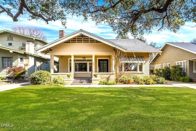 view of front of house featuring a front lawn, ceiling fan, and a porch