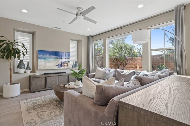 living room with ceiling fan and light hardwood / wood-style flooring