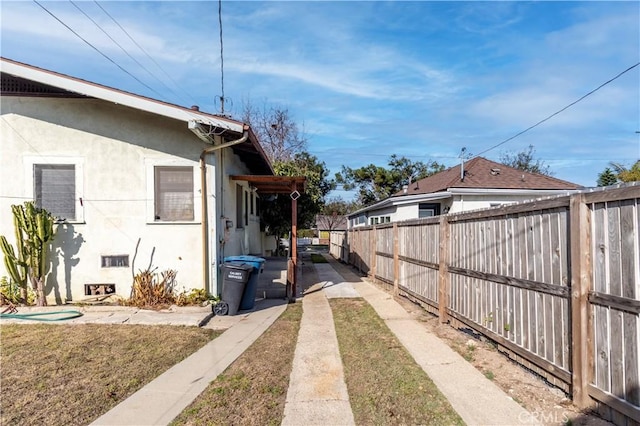 view of property exterior with a lawn and a patio area