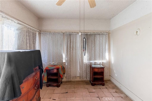 misc room with ceiling fan and a textured ceiling