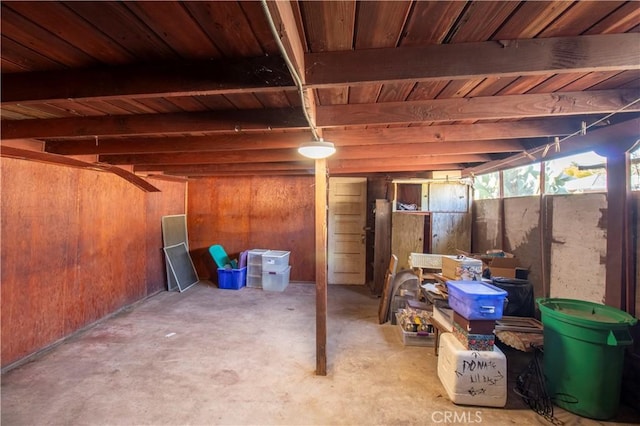 basement featuring wood walls