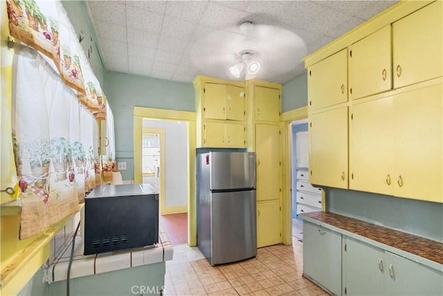 kitchen featuring tile counters and stainless steel fridge