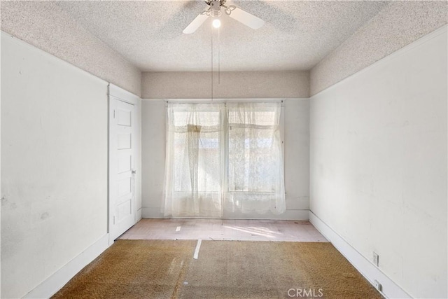 unfurnished room featuring ceiling fan and a textured ceiling