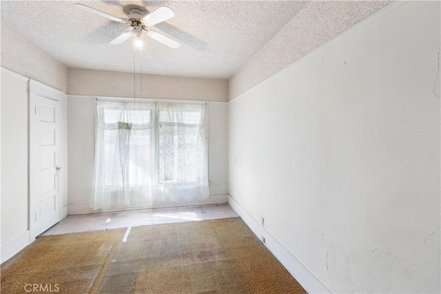 unfurnished room with ceiling fan, light carpet, and a textured ceiling