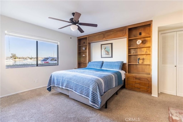 bedroom featuring carpet, baseboards, ceiling fan, and a closet