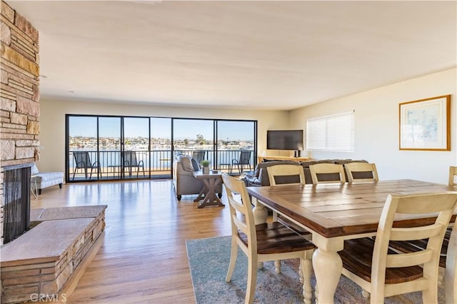 dining space with light wood finished floors and a fireplace