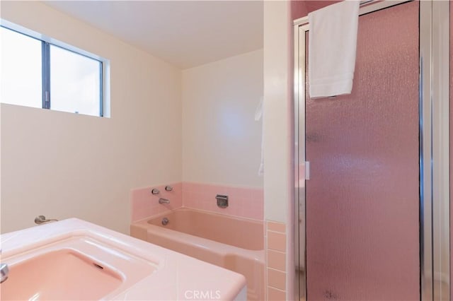 bathroom with a stall shower and a garden tub