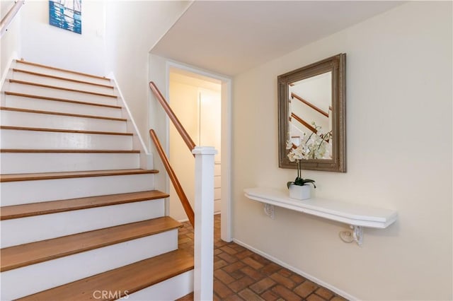 stairway featuring brick floor