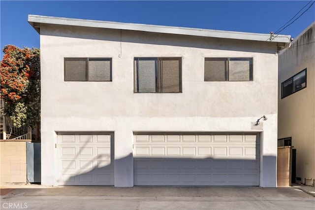 view of front of home with a garage and stucco siding