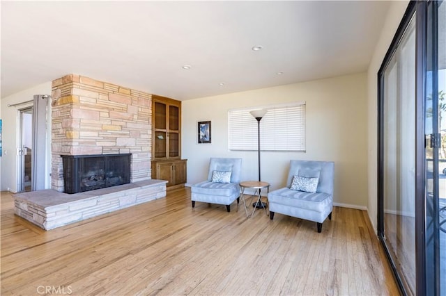 living area featuring a wealth of natural light, a fireplace, wood finished floors, and recessed lighting