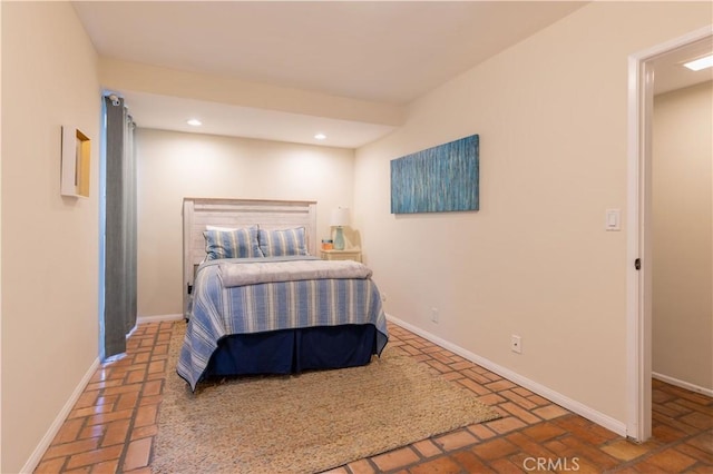 bedroom featuring brick floor, recessed lighting, and baseboards