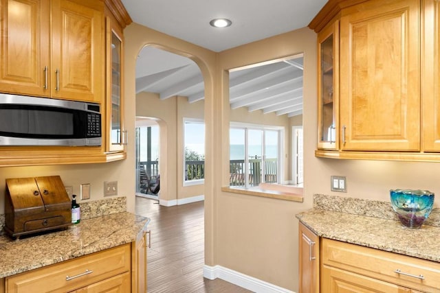 6130 Terryhill Dr, La Jolla, CA 92037 - kitchen featuring stainless steel microwave, arched walkways, baseboards, beamed ceiling, and glass insert cabinets