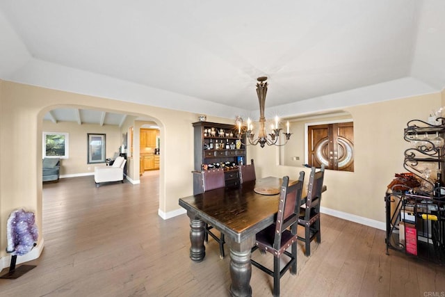 6130 Terryhill Dr, La Jolla, CA 92037 - dining area featuring arched walkways, hardwood / wood-style floors, baseboards, a raised ceiling, and a chandelier