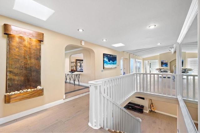 6130 Terryhill Dr, La Jolla, CA 92037 - hallway featuring wood finished floors, recessed lighting, baseboards, arched walkways, and a skylight