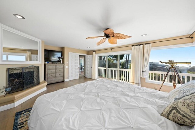 6130 Terryhill Dr, La Jolla, CA 92037 - bedroom with access to outside, a fireplace with raised hearth, wood finished floors, recessed lighting, and ceiling fan