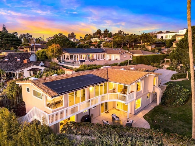 6130 Terryhill Dr, La Jolla, CA 92037 - rear view of house featuring solar panels, a patio, a balcony, a residential view, and stucco siding