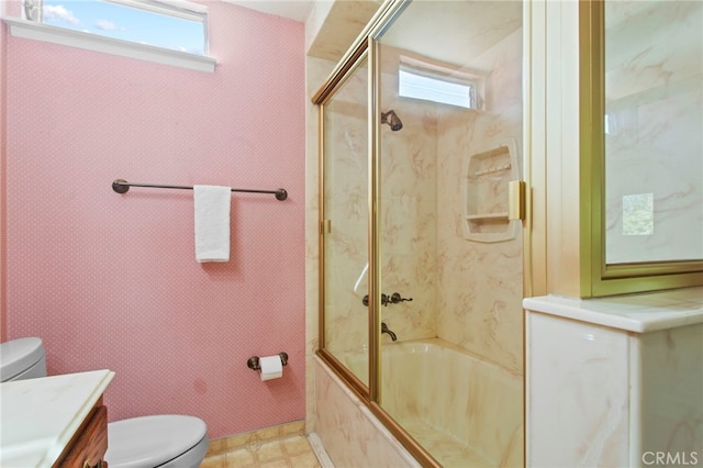 full bathroom featuring vanity, shower / bath combination with glass door, and toilet