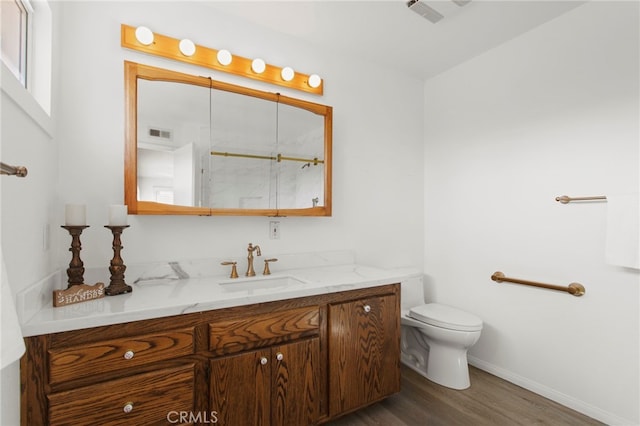 bathroom with vanity, toilet, and wood-type flooring