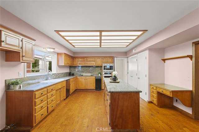 kitchen with appliances with stainless steel finishes, tasteful backsplash, light stone countertops, light hardwood / wood-style floors, and a kitchen island