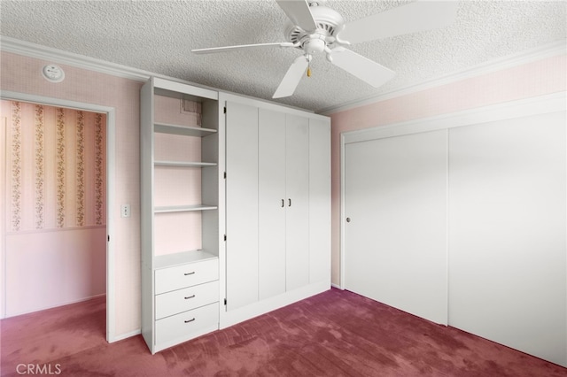 unfurnished bedroom featuring ornamental molding, carpet, a textured ceiling, and a closet