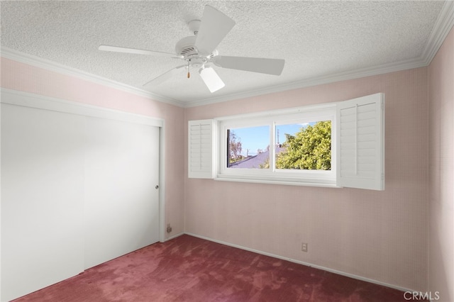 empty room with ceiling fan, crown molding, a textured ceiling, and dark colored carpet