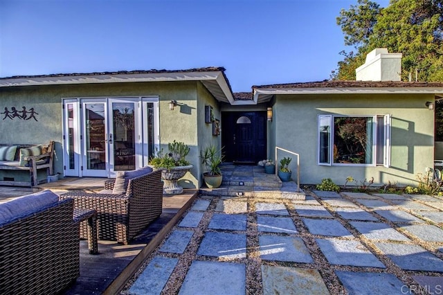 back of property featuring an outdoor living space, a patio area, and a deck