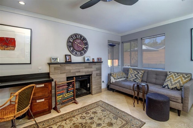 living room with ceiling fan, ornamental molding, a tile fireplace, and light tile patterned floors