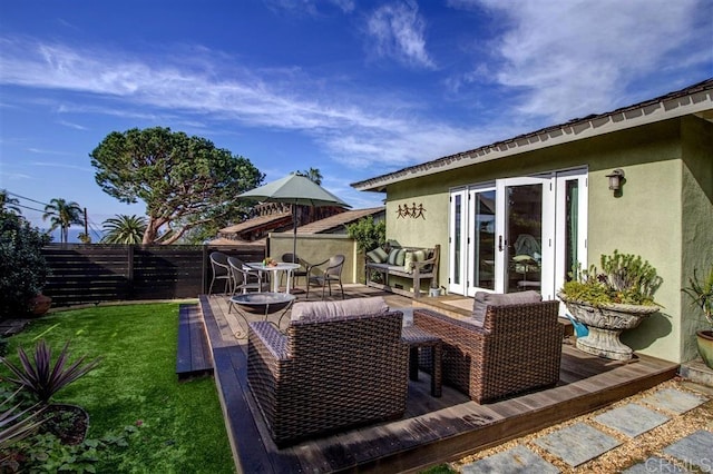 wooden terrace featuring french doors, an outdoor living space, and a lawn