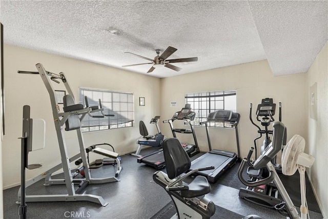 exercise room with ceiling fan and a textured ceiling