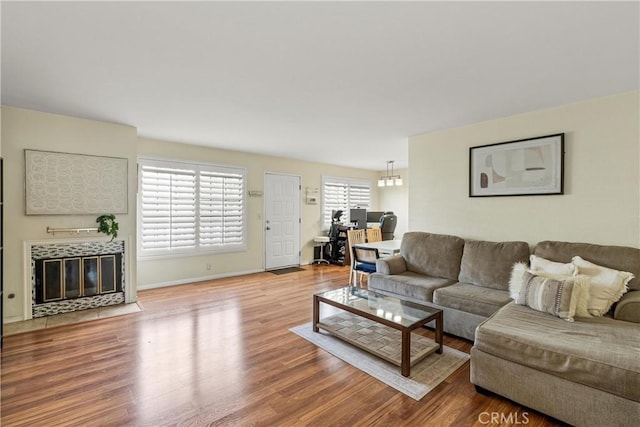 living room featuring a tiled fireplace and wood-type flooring