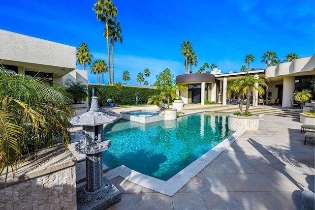 view of pool featuring a patio area and an in ground hot tub