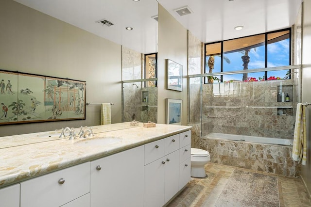 full bathroom with tiled shower / bath combo, vanity, and toilet