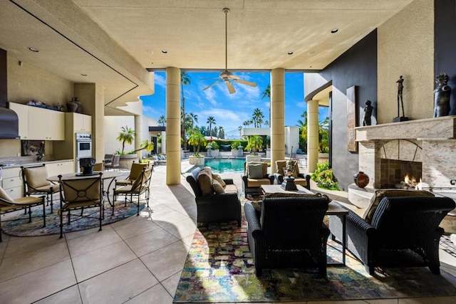 view of patio featuring ceiling fan and an outdoor stone fireplace