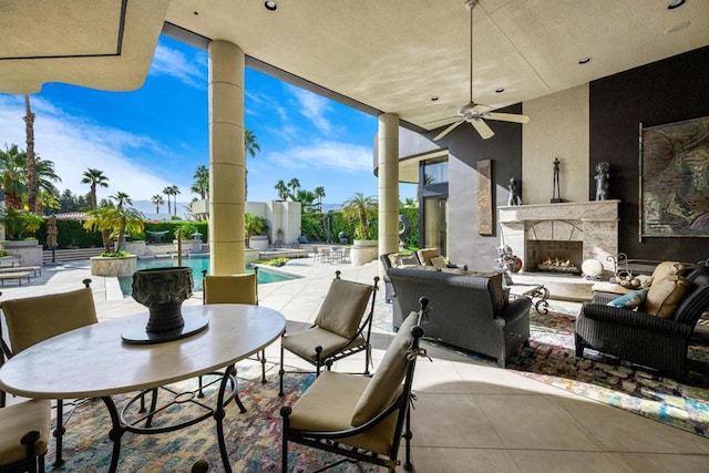 view of patio / terrace featuring ceiling fan and an outdoor fireplace