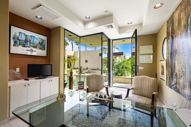 sitting room with light tile patterned flooring, a wall of windows, and a raised ceiling