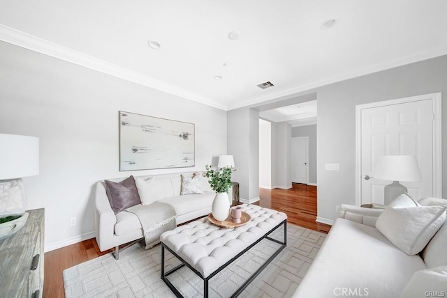 living room featuring crown molding and light hardwood / wood-style floors