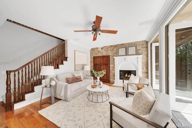 living room with ornamental molding, ceiling fan, and light hardwood / wood-style flooring