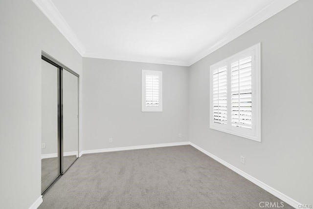 unfurnished bedroom with ornamental molding, carpet flooring, and a closet