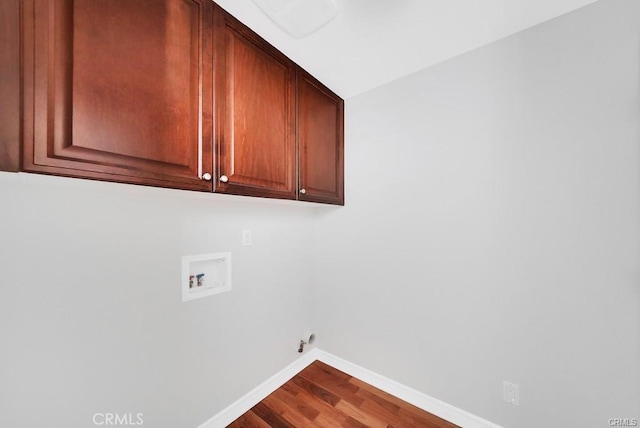 clothes washing area with washer hookup, wood-type flooring, cabinets, and gas dryer hookup