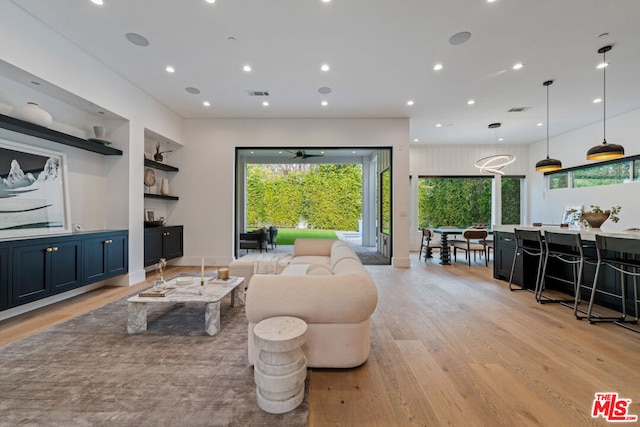 living room featuring light hardwood / wood-style flooring and built in shelves