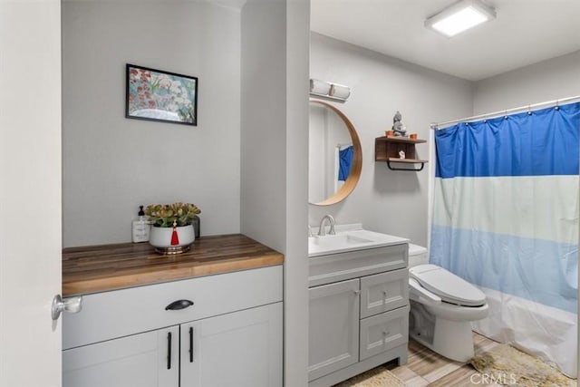 full bathroom with vanity, wood-type flooring, shower / bath combination with curtain, and toilet