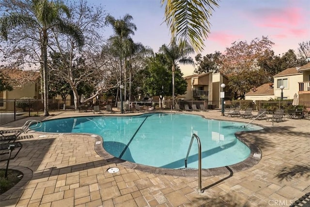 pool at dusk featuring a patio area