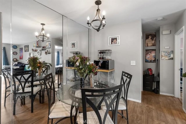 dining area with hardwood / wood-style floors and a chandelier